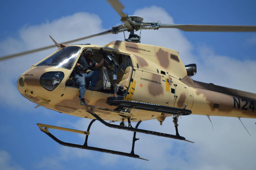 alt="Guest firing from helicopter door in Gunship Helicopters Door Gunner Experience"