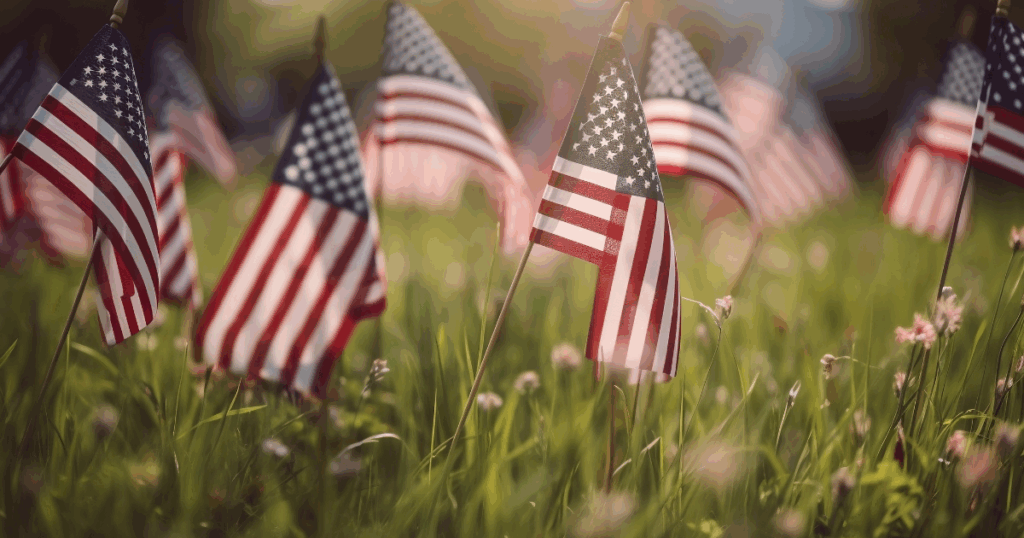 Memorial Day Weekend in Las Vegas: Why Gunship Helicopters Should Be on Your Itinerary 1 Small American flags planted in a grassy field, symbolizing patriotic remembrance and celebration on Memorial Day or Independence Day.