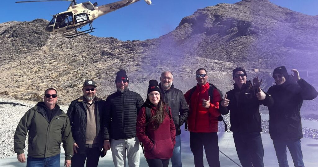 A group of guests pose after completing a tactical helicopter shooting adventure with Gunship Helicopters in the Mojave Desert near Las Vegas.
