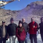 A group of guests pose after completing a tactical helicopter shooting adventure with Gunship Helicopters in the Mojave Desert near Las Vegas.