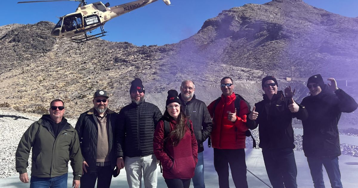 A group of guests pose after completing a tactical helicopter shooting adventure with Gunship Helicopters in the Mojave Desert near Las Vegas.
