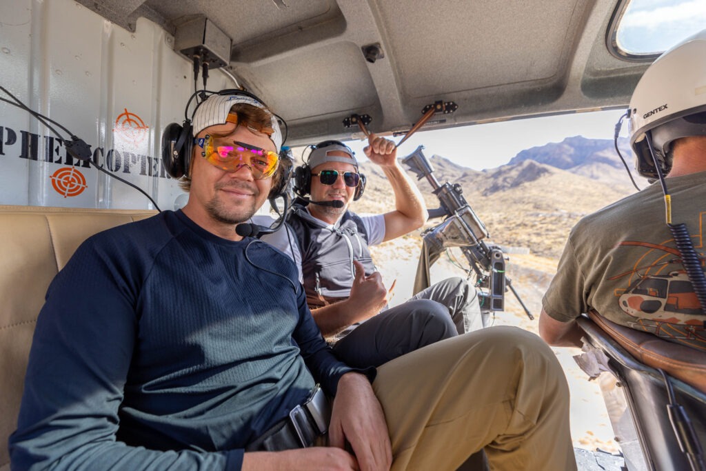 deluxe battle buddy - Two men inside a helicopter smiling and preparing for a Gunship Helicopters shooting experience