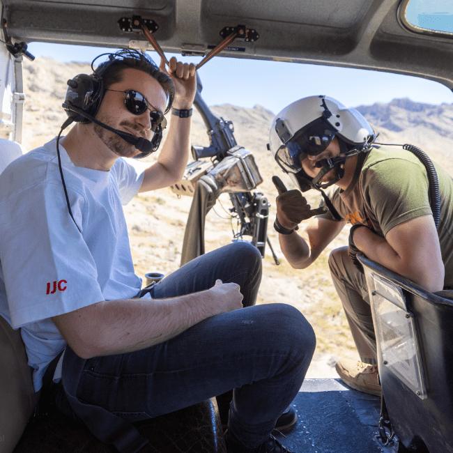 1 person package: Smiling guest inside helicopter with headset and tactical gear