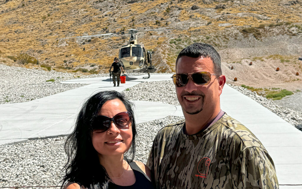 battle buddy Smiling couple posing in front of helicopter landing zone in Las Vegas desert