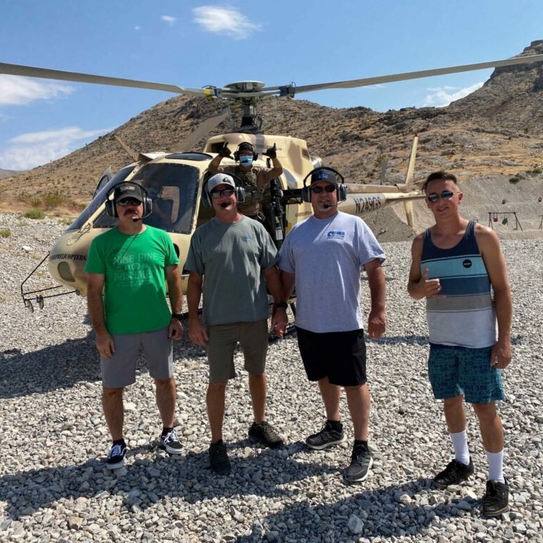4 men in front of a helicopter ready for their gunship shooting tour in Las Vegas