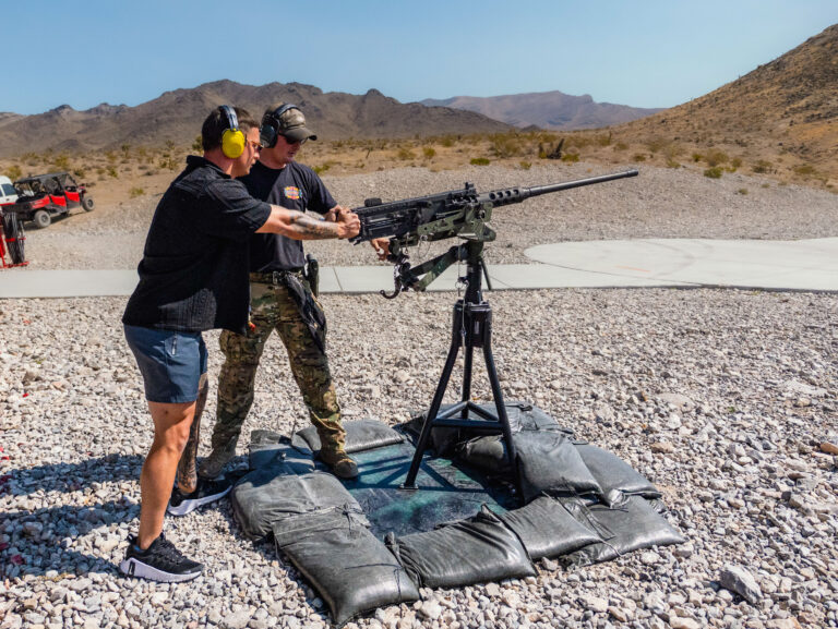 Guest receiving guidance from a range safety officer while firing the M240 machine gun at Gunship Helicopters’ outdoor shooting range near Las Vegas.
