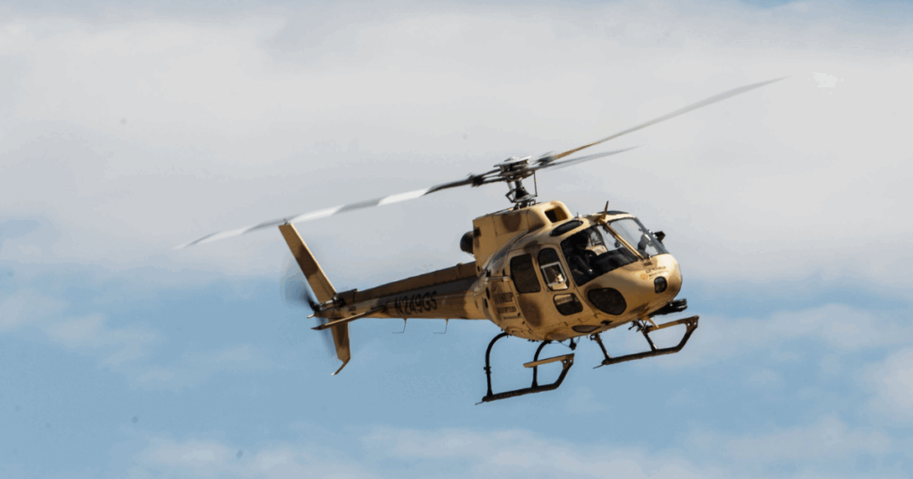 Veteran guest firing from open-door helicopter during veteran-approved aerial shooting experience with discounts in Las Vegas.