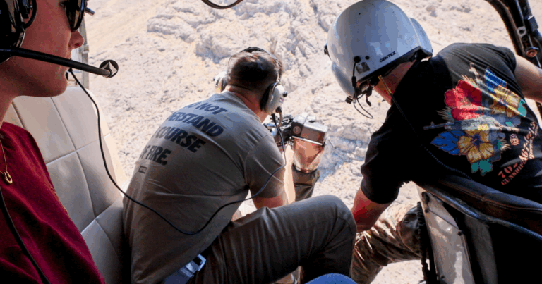 Veteran-led helicopter adventure in Las Vegas – guest preparing to fire from open-door aircraft over Mojave Desert