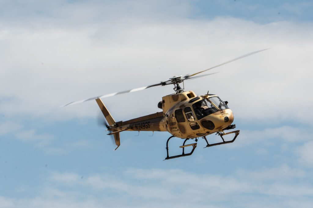 Gunship Helicopters crew posing by aircraft at their aerial gun range in Las Vegas, celebrating global adventure recognition and a true one of kind experience.