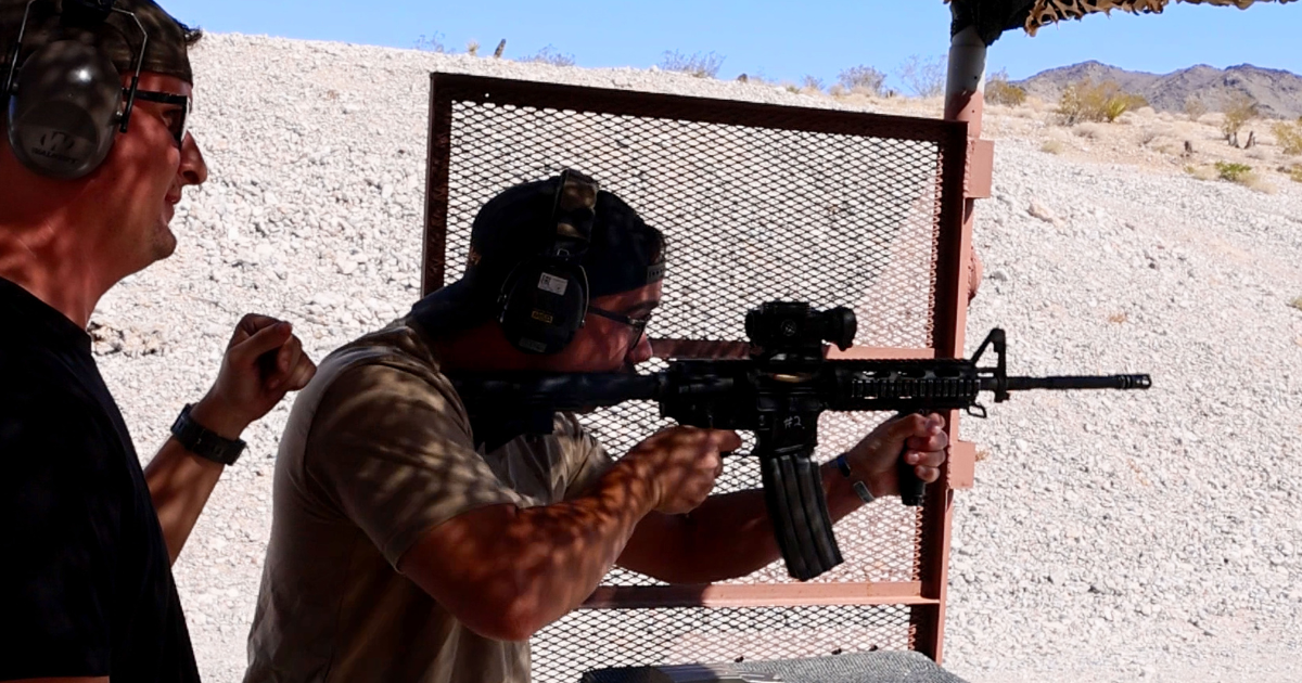Veteran instructor guiding guest through firearm handling during safety briefing at Gunship Helicopters Las Vegas