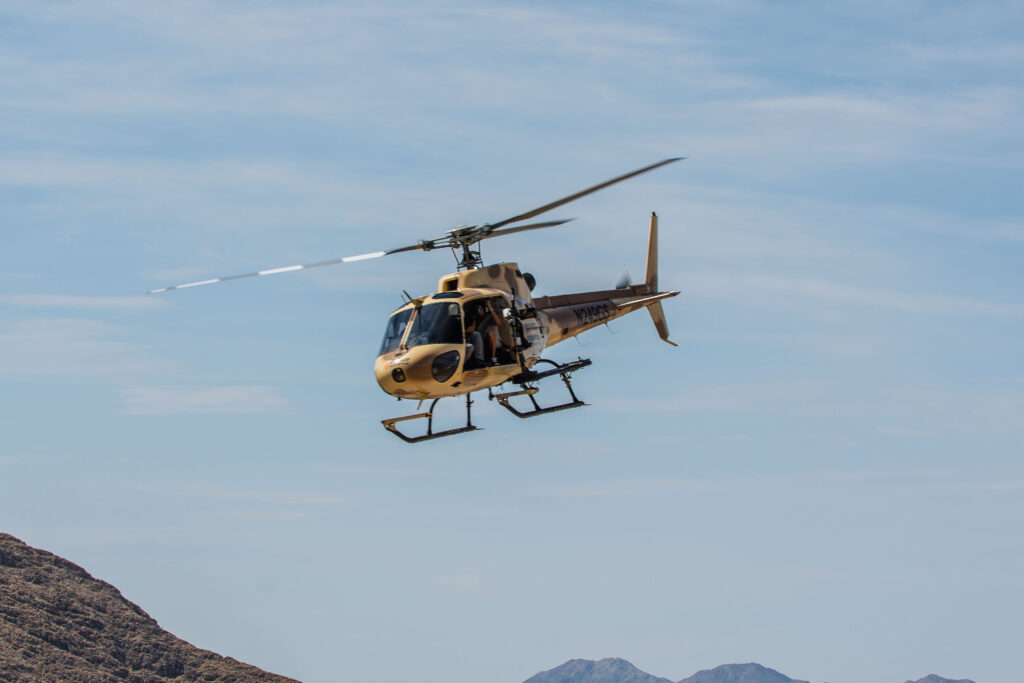 Helicopter in flight during the aerial shooting experience at Gunship Helicopters in the Mojave Desert