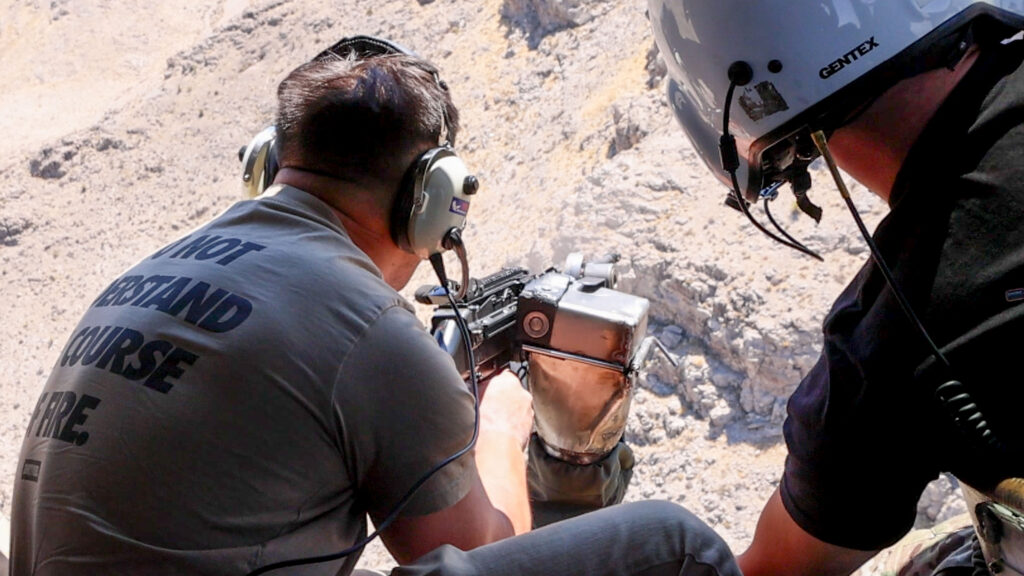 Range safety officer guiding a guest during the helicopter shooting safety briefing at Gunship Helicopters in Nevada