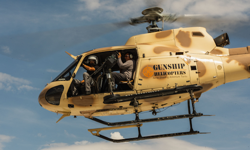 Range safety officers oversee a helicopter shooting experience in Nevada, ensuring firearm safety and coordination during aerial adventure tours.