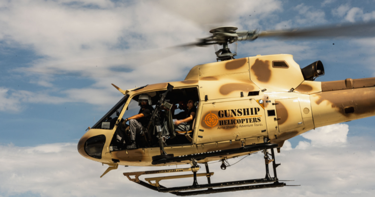 Gunship Helicopters Nevada their aircraft in flight during a helicopter gunship Nevada experience featuring an open-door aerial shooting adventure over the Nevada desert.