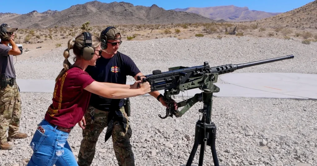 Guest operating a mounted M2 Browning .50 caliber machine gun with guidance from a range safety officer at a Nevada desert shooting range